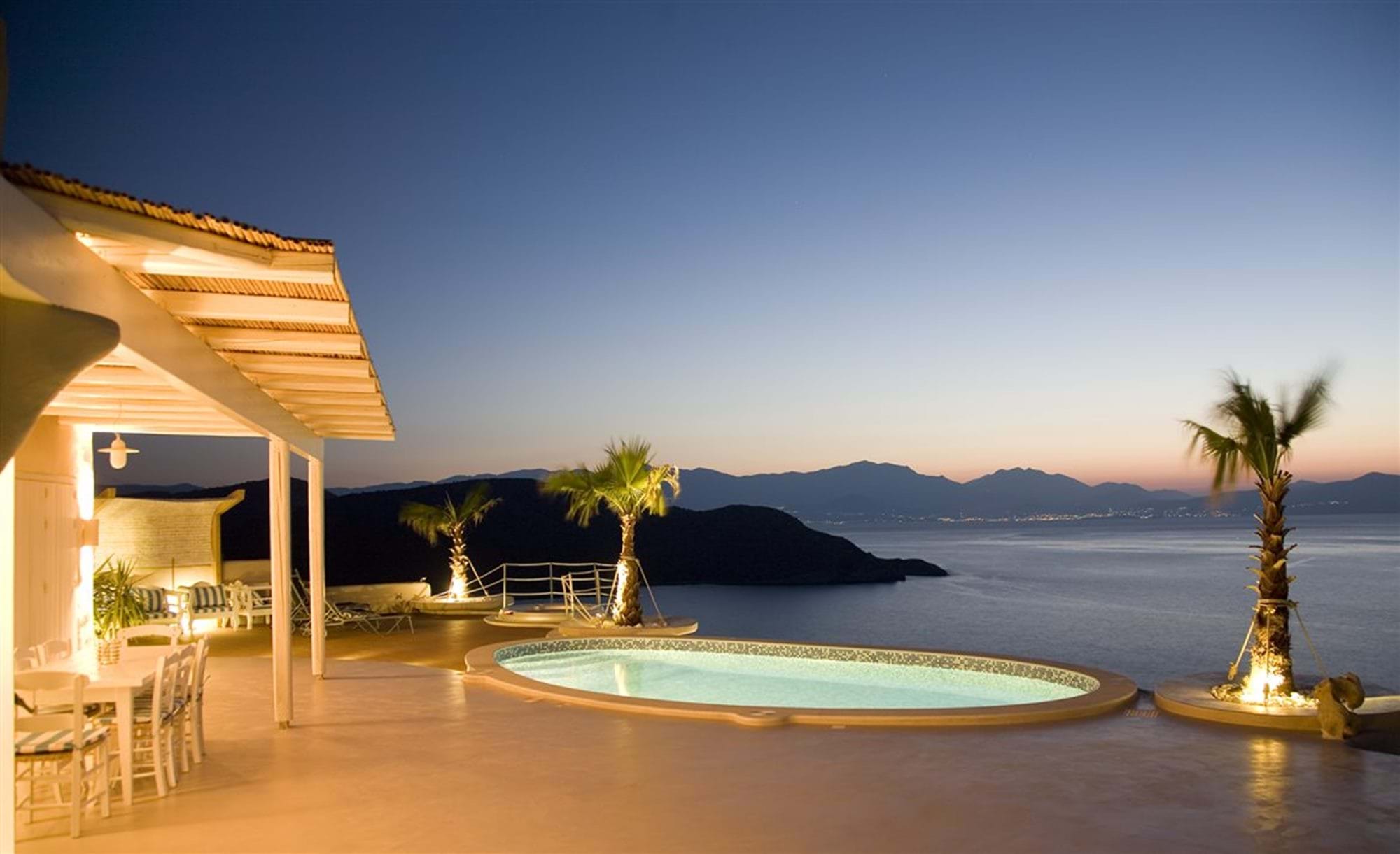 Villa terrace and pool lit at dusk above the gulf