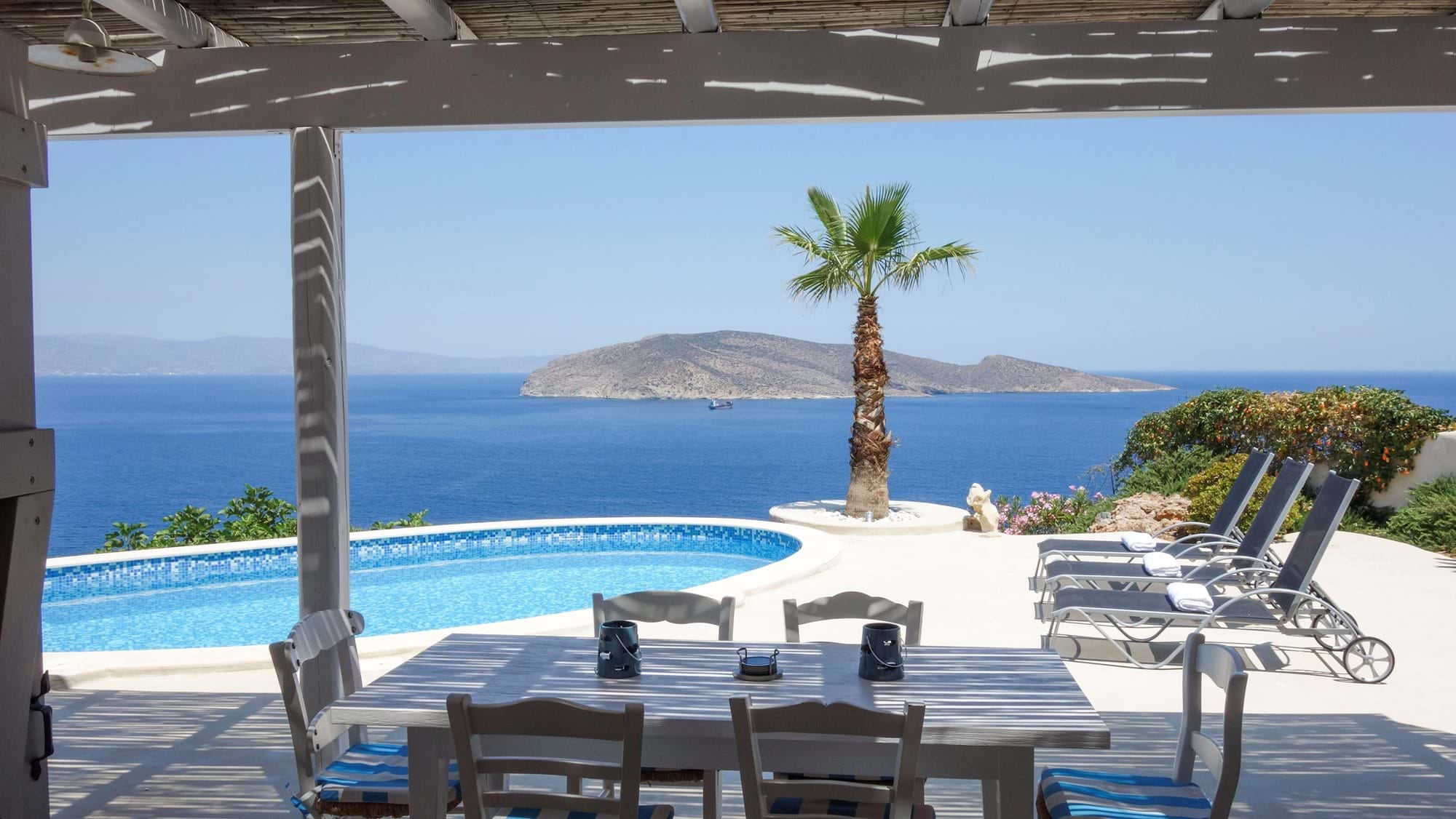 Pool terrace with dining table and Pseira Island